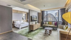 A modern hotel room with a bed, seating area, and a large window with a city view. - Metropolis Hotel (Sanya Bay Coconut Dream Corridor) (Sanya)