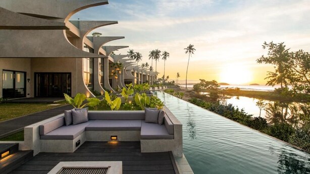 A modern resort with a long pool, outdoor seating, and a sunset view. - The Hotel Elizabeth Resort and Villas (San Vicente)