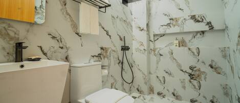 Un baño con bañera, inodoro y ducha.