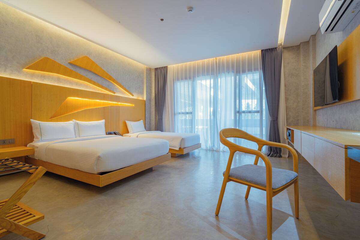 Une chambre d’hôtel moderne avec un grand lit, un bureau et une chaise.