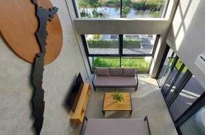 Een modern interieur met een bank, salontafel en een bijzonder kunstwerk aan de muur.