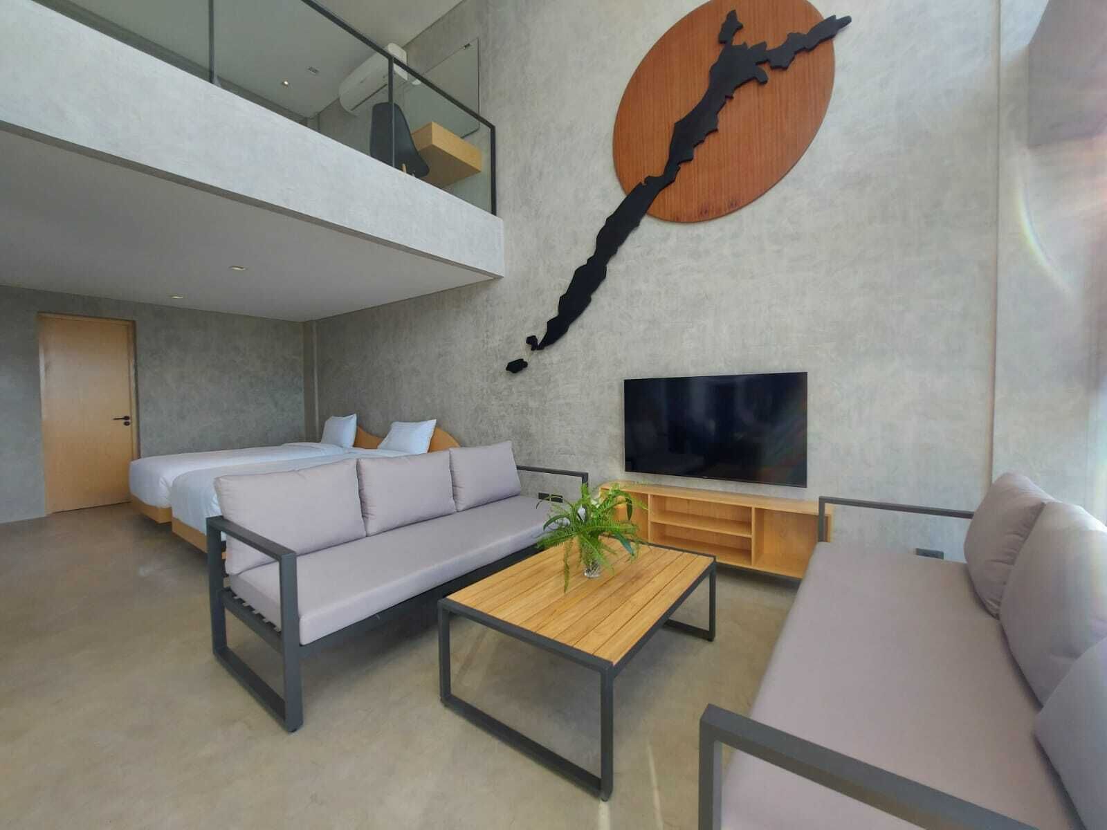 Una sala de estar moderna con un sofá, una mesa de centro, un televisor y una gran obra de arte en la pared.