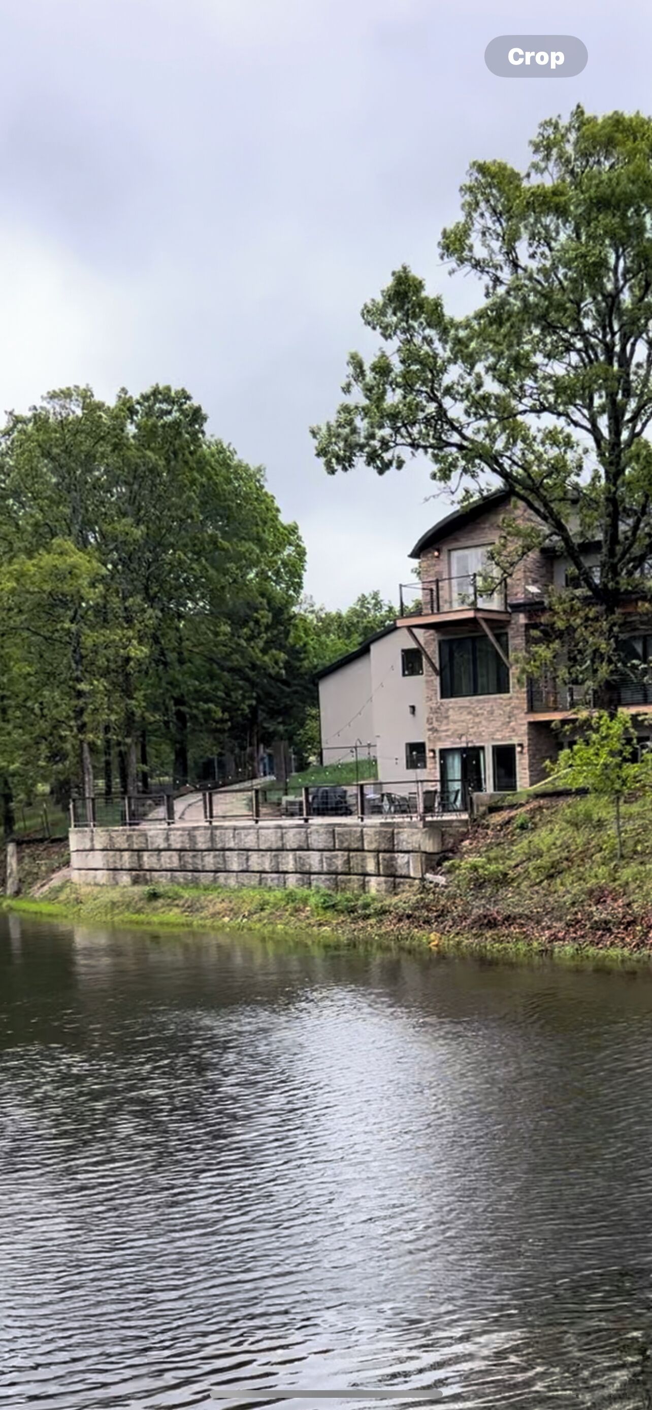 Private getaway in modern mountain design. Overlooking water on deck in nature.