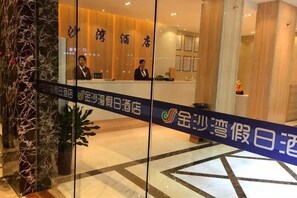 A hotel reception area with a reception desk, a wooden interior, and a blue banner with text.
