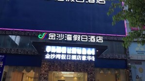 A hotel with a neon sign and a visible entrance.
