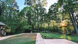 A residential area with a well-maintained lawn, a concrete pathway, and tall trees. - Cozy North Raleigh Guest House - near RDU, DTR, + major Hospitals (Raleigh)