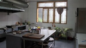 Una cocina con una isla grande, electrodomésticos de acero inoxidable y un ventanal con un diseño de celosía tradicional.