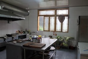 Une cuisine dotée d’un grand îlot central, d’une cuisinière et de divers ustensiles de cuisine.