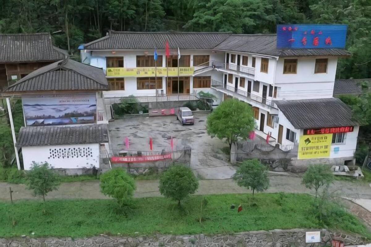 Un immeuble à plusieurs étages de style architectural traditionnel, doté d’un espace de stationnement et d’une enseigne.