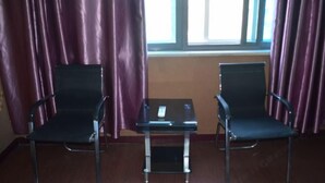 A room with two black chairs, a small table, and a window with curtains. - Kangchao Hotel, Yueqing (Yueqing)