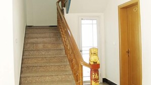Una escalera con barandilla de madera y una escultura de cabeza de león decorativa en la parte superior.