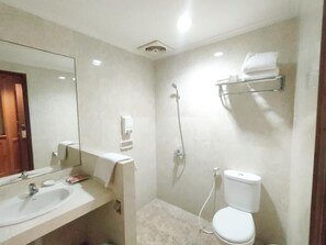 A bathroom with a sink, mirror, toilet, shower, and towel rack. - Ijen View Hotel and Resort (Bondowoso)