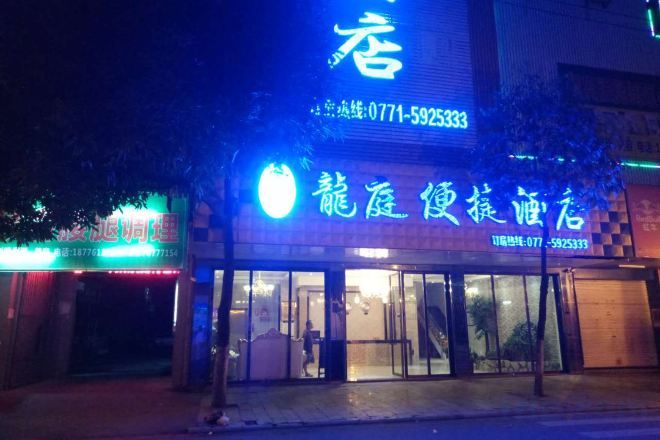 A hotel with a prominent sign displaying the name and contact number.