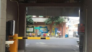 A gated entrance with a yellow barrier, a signboard, and a scooter parking area. - Longting Convenience Hotel (Binyang Yongwu Street Branch) (Binyang)