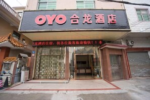 Ett hotell med en skylt som visar namnet ”OYO” och kinesiska tecken.