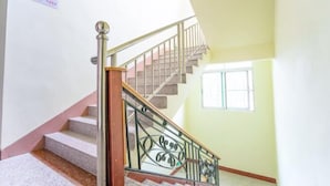 A staircase with metal railings and a handrail, leading to an upper floor. - He Long Hotel (Shaoguan)