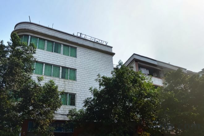 Un edifici de diverses plantes amb teulada plana i un balcó a la planta superior.
