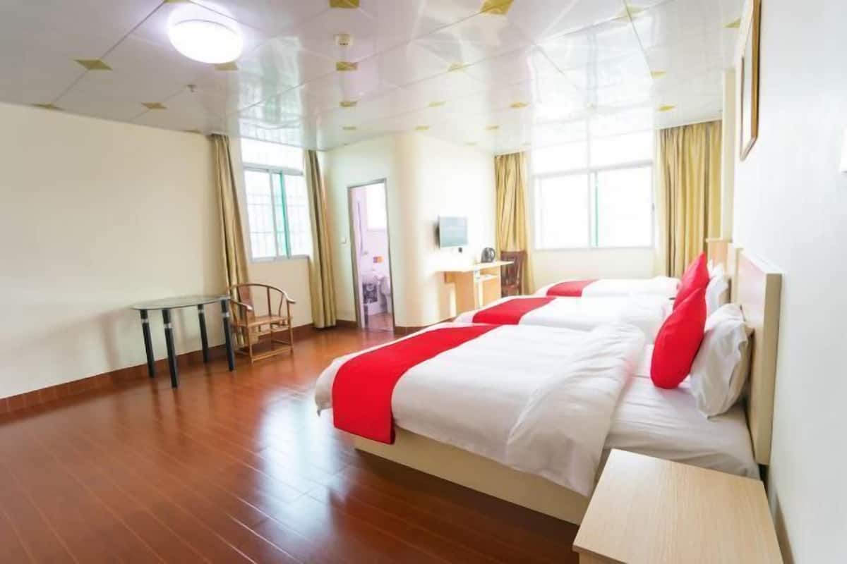 A hotel room with a large bed, a desk, and a chair.