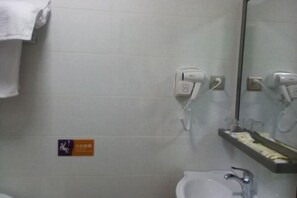 A bathroom with a white sink, a mirror, a towel rack, and a hand dryer. - He Long Hotel (Shaoguan)