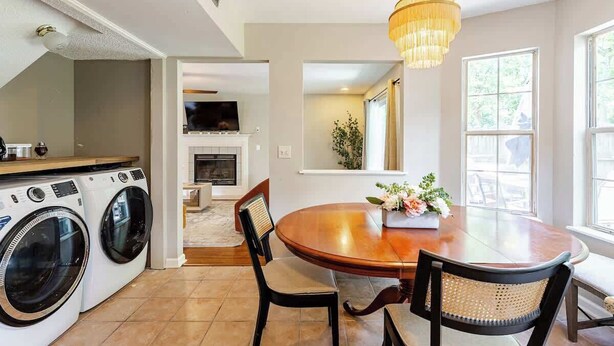 Een moderne keuken met een eethoek, inbouwapparatuur en een kroonluchter.