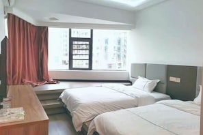 A hotel room with two beds, a desk, and a window with curtains. - Guiyang Keyuan Hotel (Wudang Xintianzhai Branch) (Guiyang)