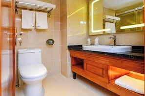 Un baño moderno con inodoro, tocador y espejo.