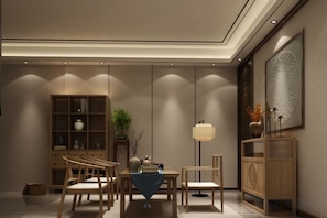 Un comedor moderno con una mesa, sillas y un jarrón decorativo.