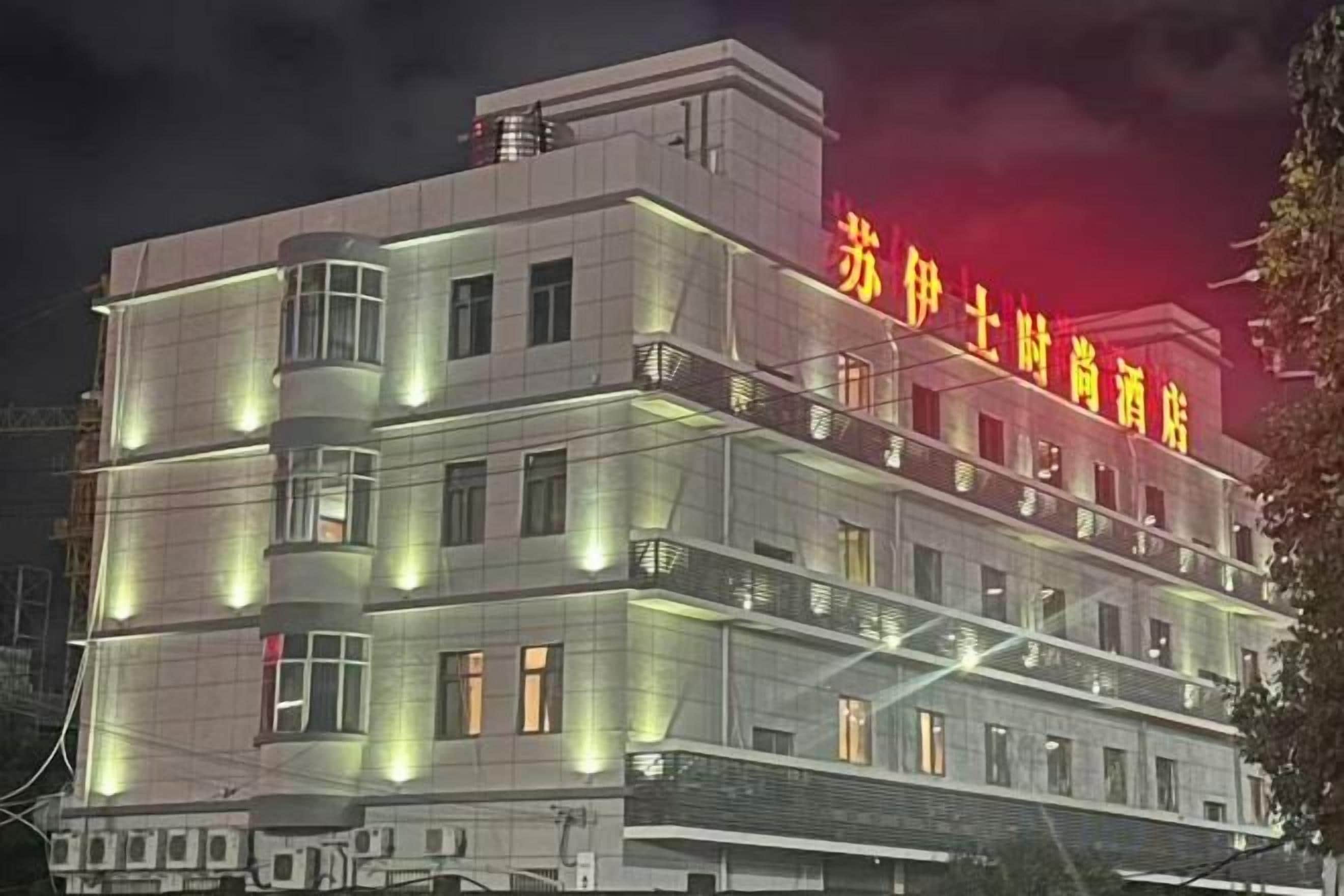 Ein mehrstöckiges Hotel mit beleuchteter Beschilderung und modernem Architekturstil.