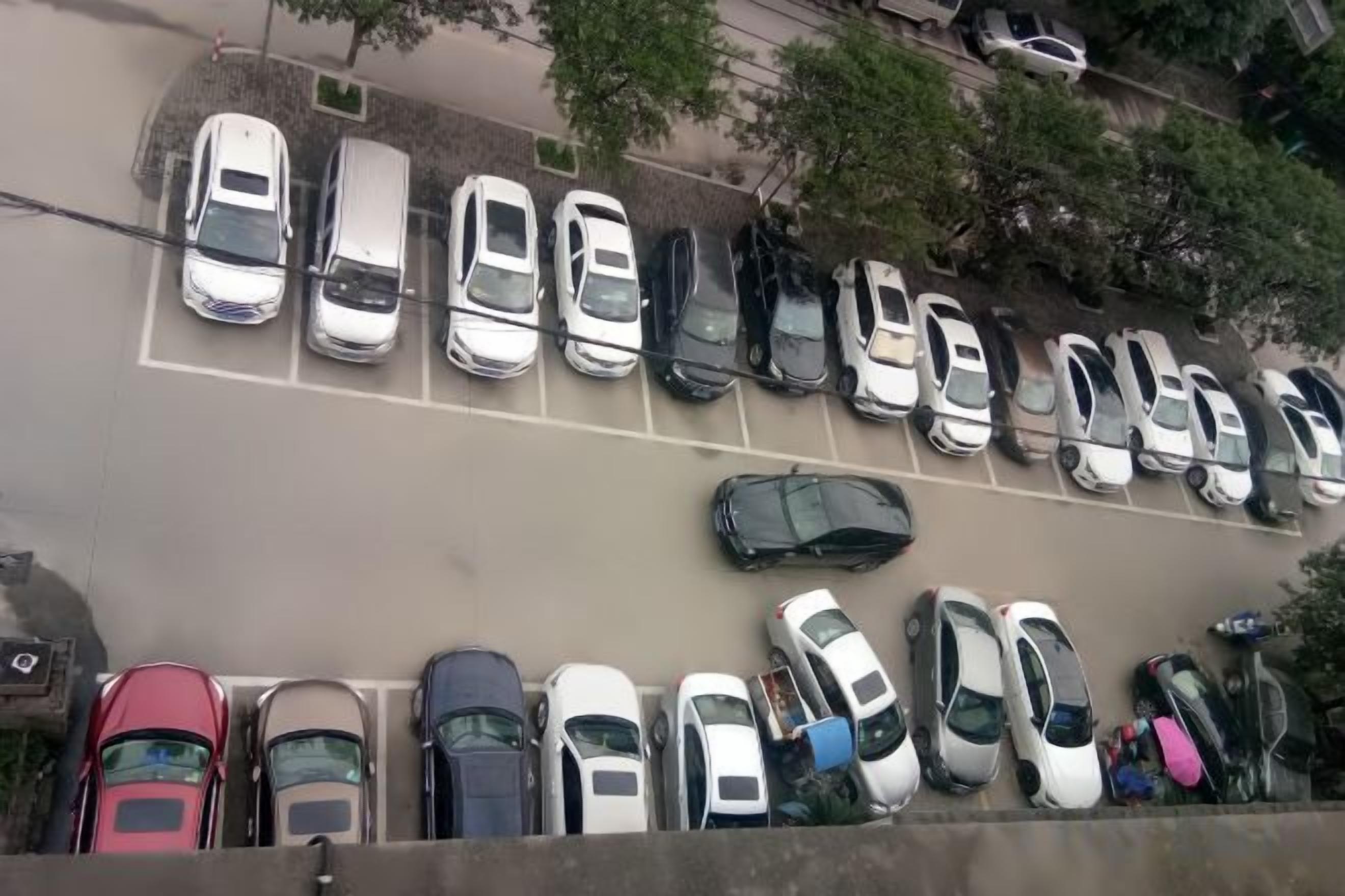 A parking lot with multiple rows of parked cars.