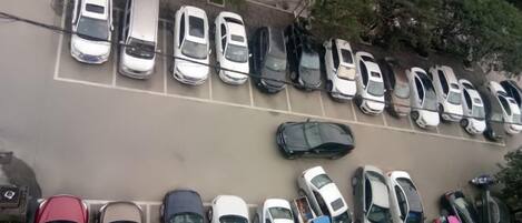 A parking lot with multiple rows of parked cars.