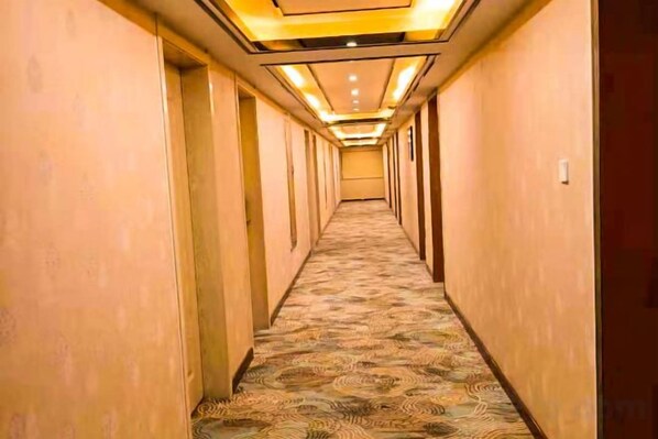 A hotel corridor with carpeted flooring and doors on both sides. - Yuzhong GongXiao Hotel (Yuzhong)