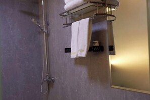 Ein Badezimmer mit Dusche, Handtuchhalter und Spiegel.