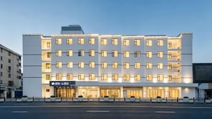 A multi-story hotel with a modern facade, multiple balconies, and a well-lit entrance. - Ribera Cloud Hotel (Shanghai Jinshan Petrochemical Branch) (Shanghai)