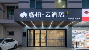 A hotel entrance with glass doors, a car parked outside, and a sign with Chinese characters. - Ribera Cloud Hotel (Shanghai Jinshan Petrochemical Branch) (Shanghai)