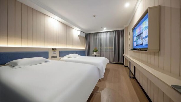A hotel room with two beds, a TV mounted on the wall, and a small table with a plant. - Ribera Cloud Hotel (Shanghai Jinshan Petrochemical Branch) (Shanghai)