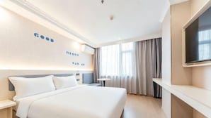 A hotel room with a large bed, a TV on the wall, and a desk with a chair. - Ribera Cloud Hotel (Shanghai Jinshan Petrochemical Branch) (Shanghai)