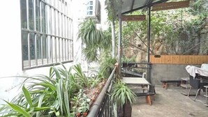Un balcone con piante in vaso, un tavolo e sedie.