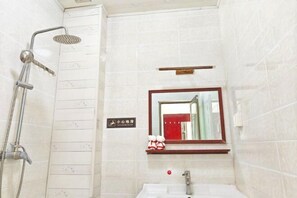 A bathroom with a shower, sink, and a mirror. - Yunjin Hotel (Yangbi)