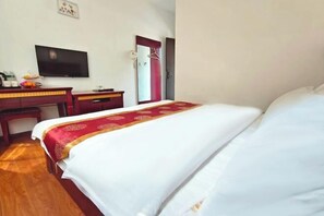 A hotel room with a bed, a desk with a television, and a wardrobe. - Yunjin Hotel (Yangbi)