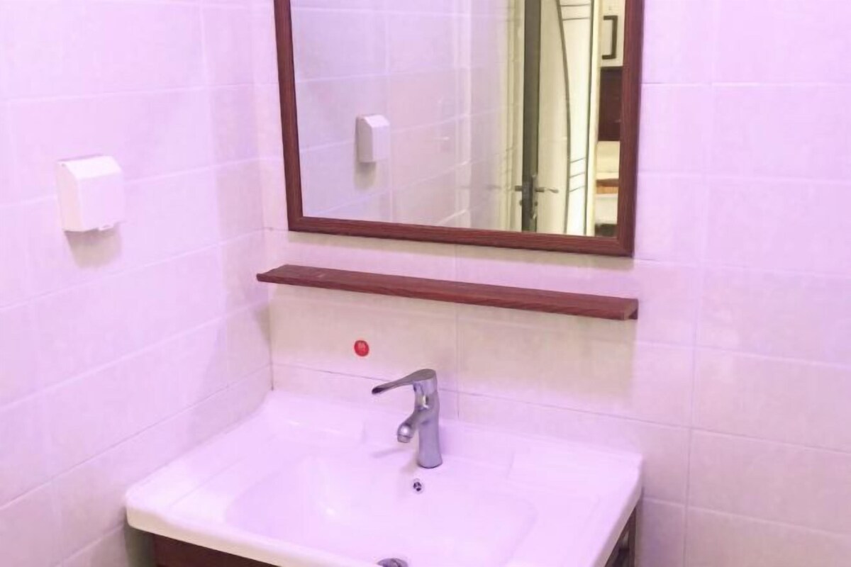 A bathroom with a white sink, a mirror, and a hand dryer.