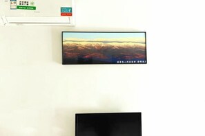 A wall-mounted television displaying a scenic landscape. - Yunjin Hotel (Yangbi)