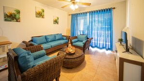 A living room with a sofa set, a coffee table, and a ceiling fan. - Room-2br Caribbean Condo In Cabarete Cen (Sosúa)
