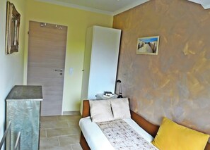 Ein Schlafzimmer mit Bett, Nachttisch, Kleiderschrank und Tür.