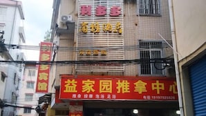 Un edificio con varios letreros, incluyendo uno de hotel y otro de centro de masajes.