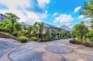 Um pátio com um padrão circular central, rodeado por edifícios residenciais com estilos arquitetônicos variados, incluindo uma estrutura de vidro moderna.
