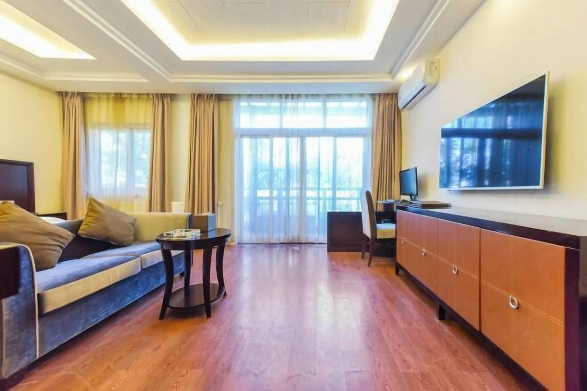 A living room with a sofa, a coffee table, a TV, and a cabinet.
