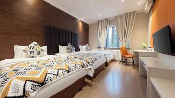 A hotel room with a large bed, a desk, and a television.