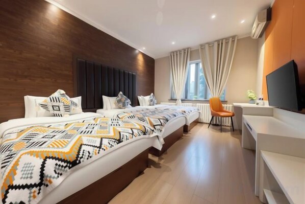 A hotel room with a large bed, a desk, and a television.