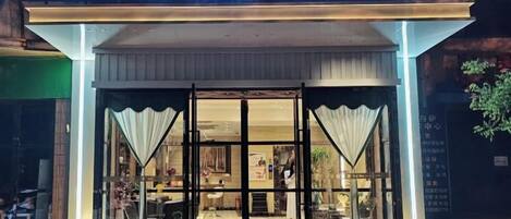 A hotel entrance with a sign reading 'SANDOU HOTEL' and a logo above the entrance.