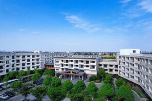 A multi-story building with a central courtyard, surrounded by trees and parking.